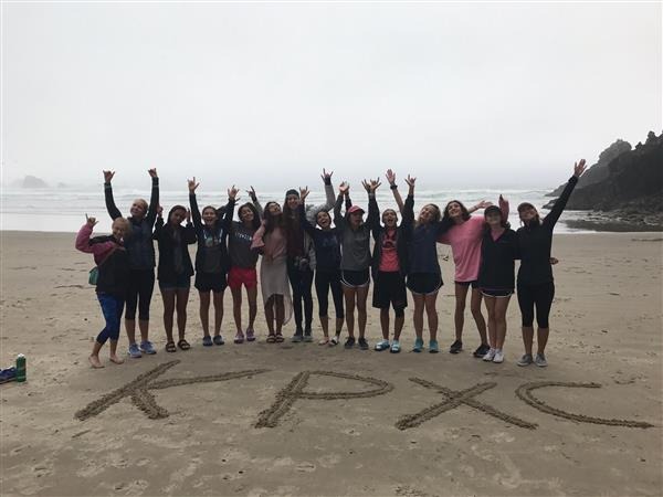 group of students posing on beach 