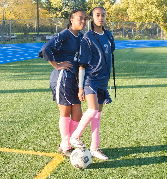 two soccer players posing on the field