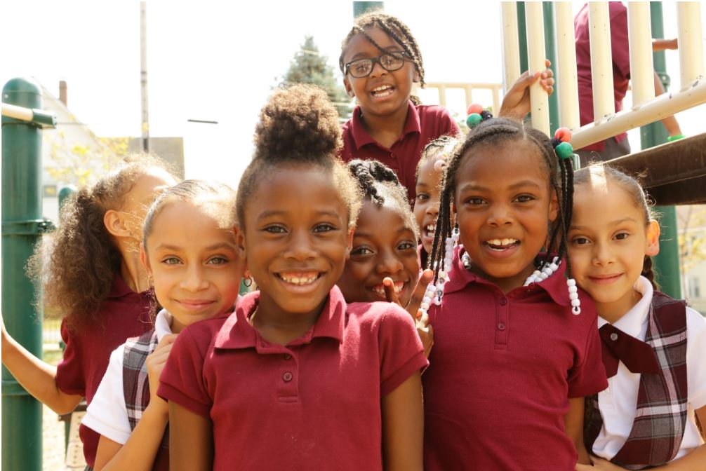 students smiling at camera in group on playground