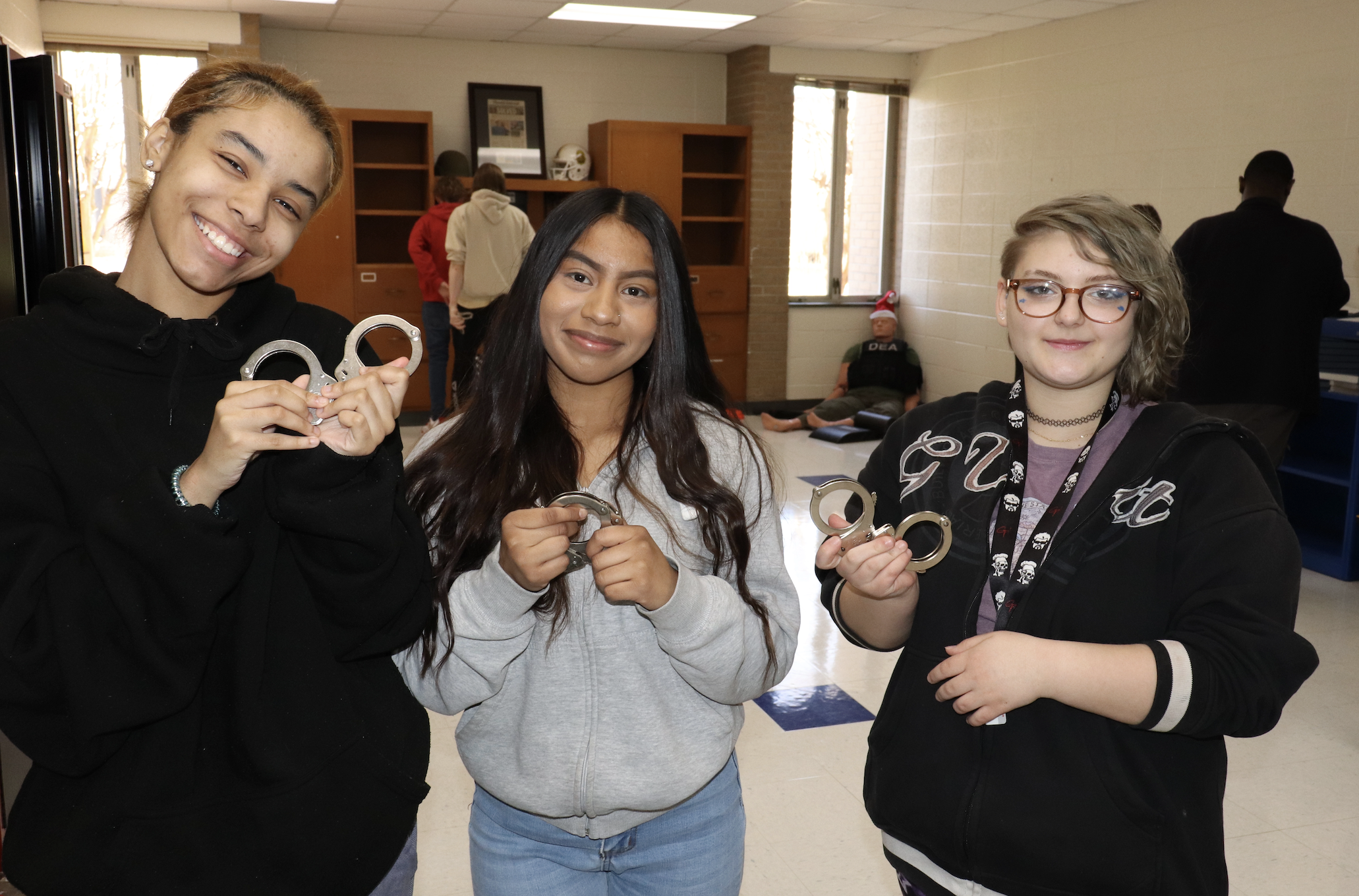 Students smiling holding handcuffs