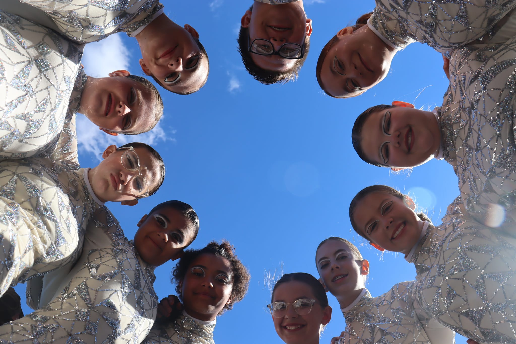 Students in a circle against blue sky
