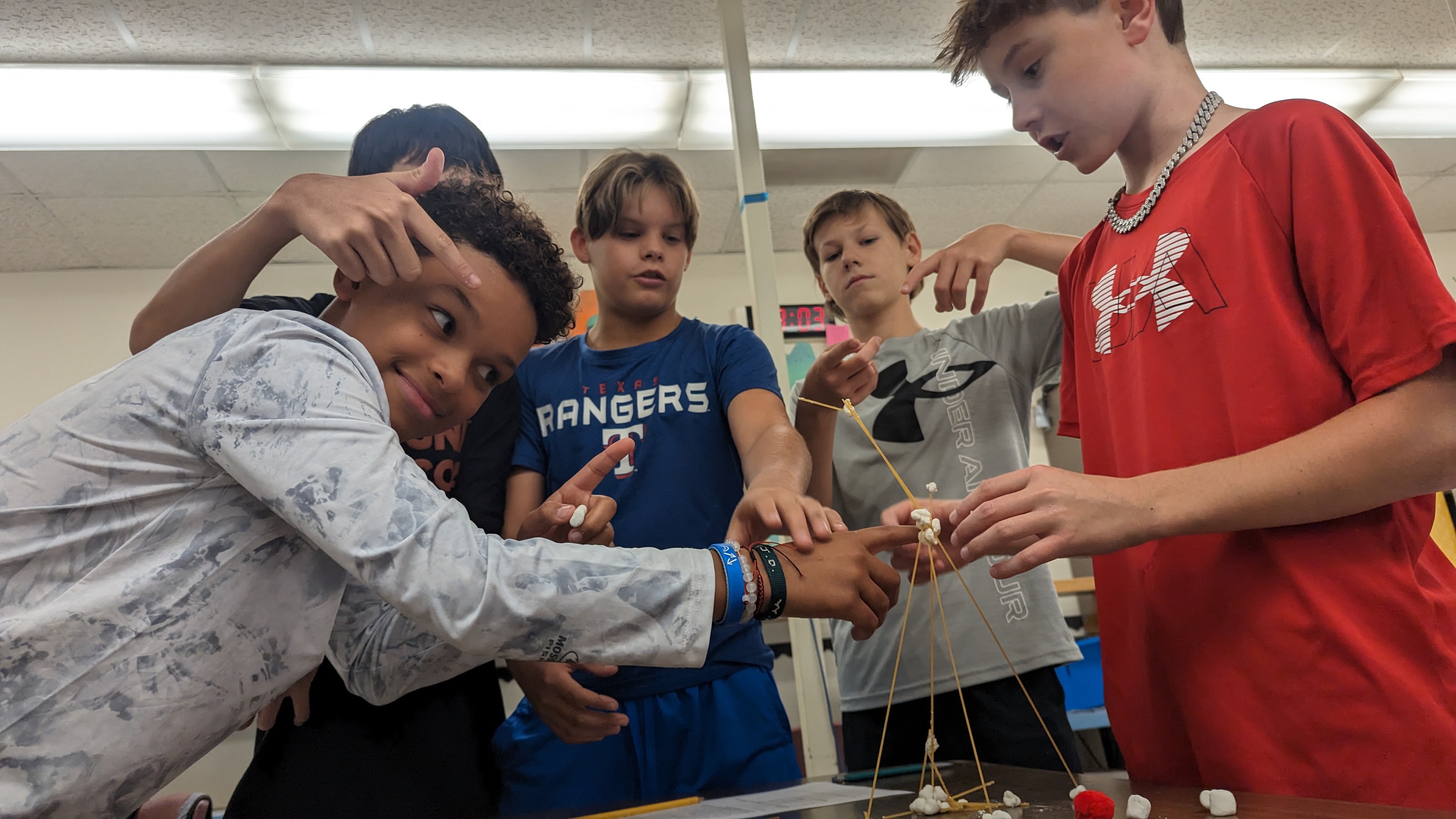 8th graders pose with their marshmallow tower