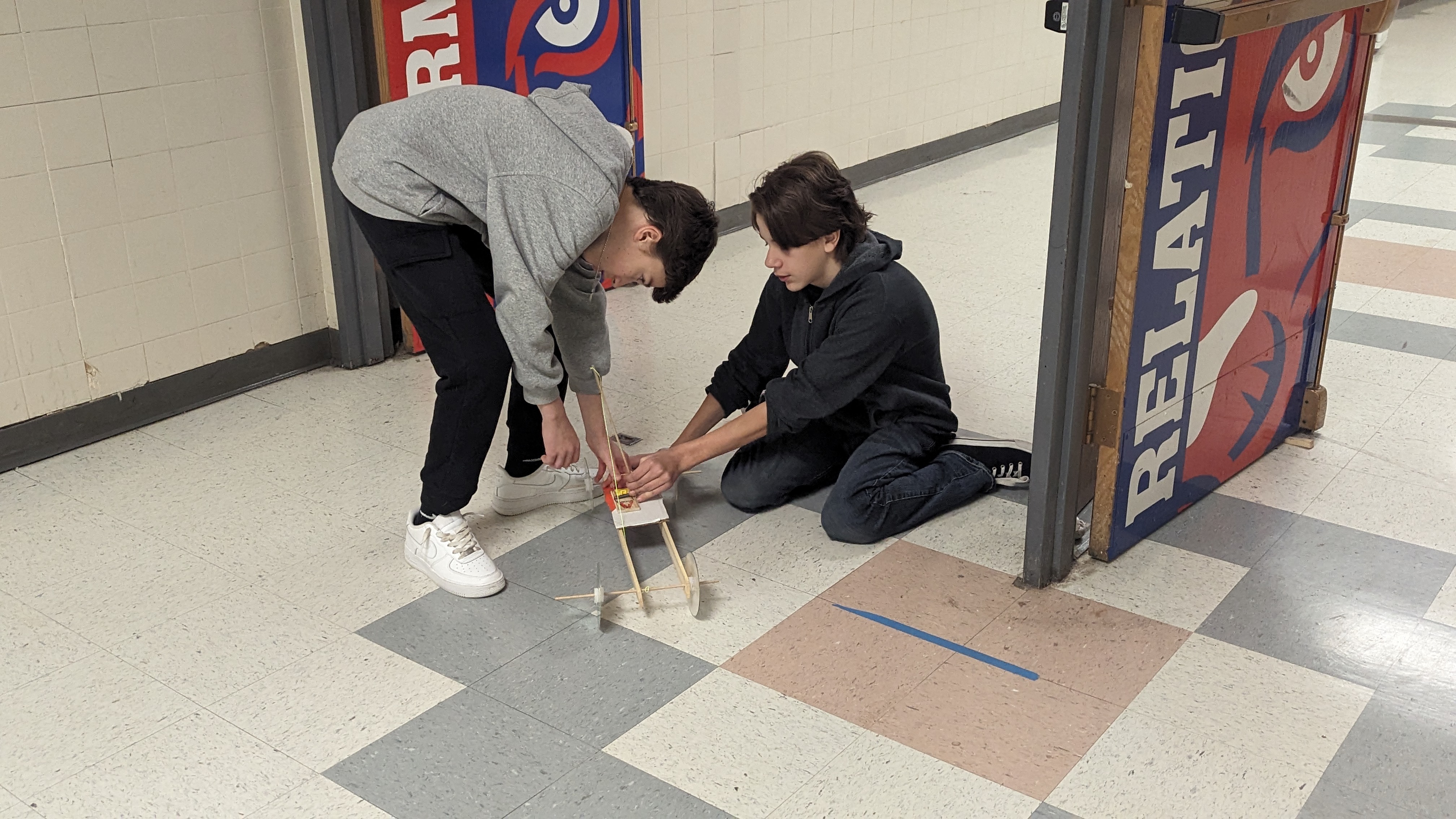 students winding up their mousetrap car