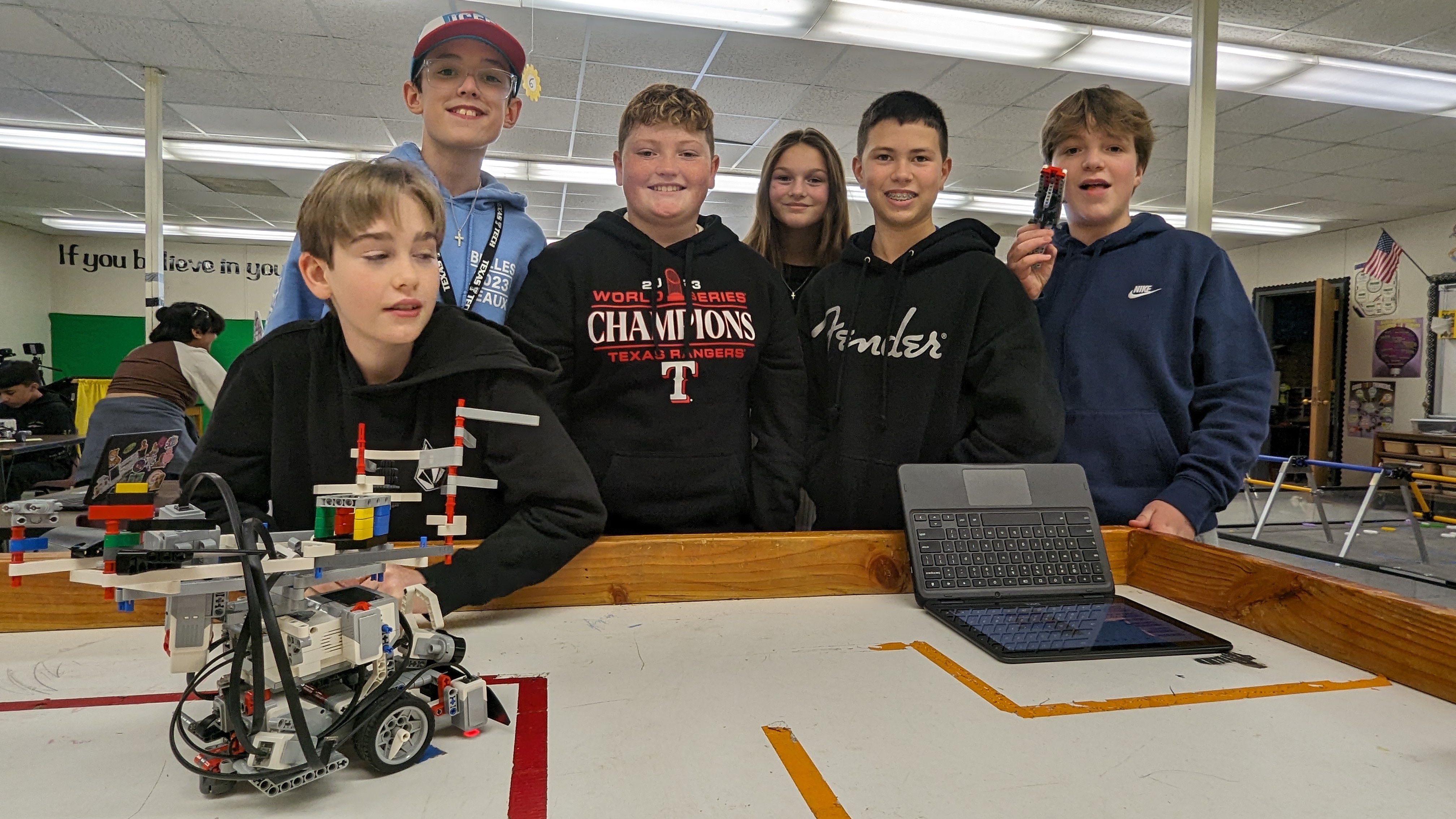 7th graders pose with their EV3 Lego robot for Sumobot project