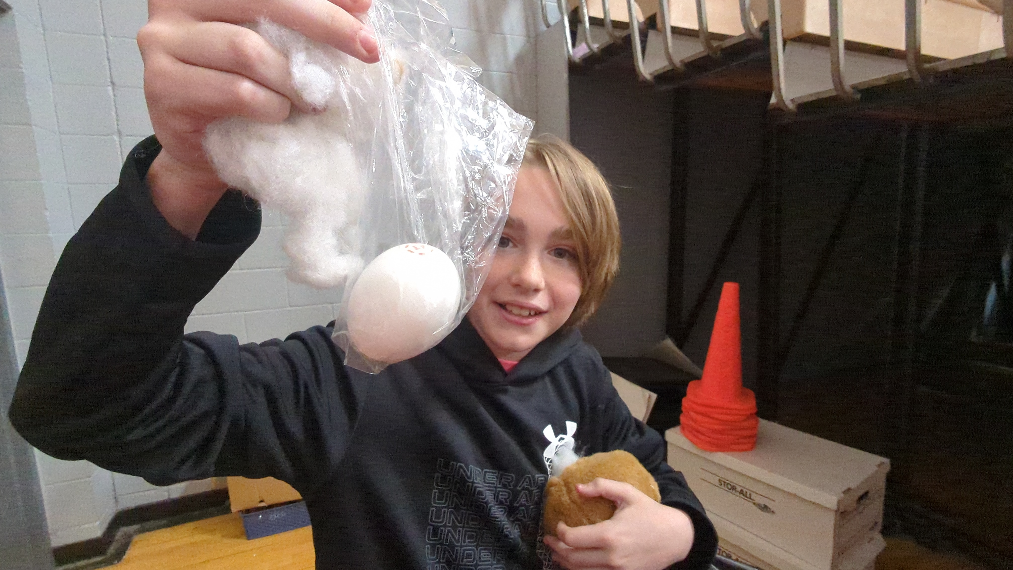 students showing off their unbroken egg after testing their egg drop design