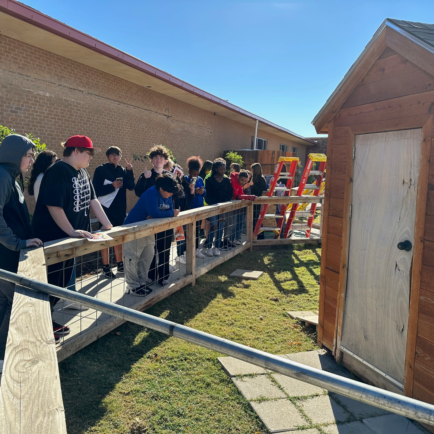 students standing and looking at materials for shed