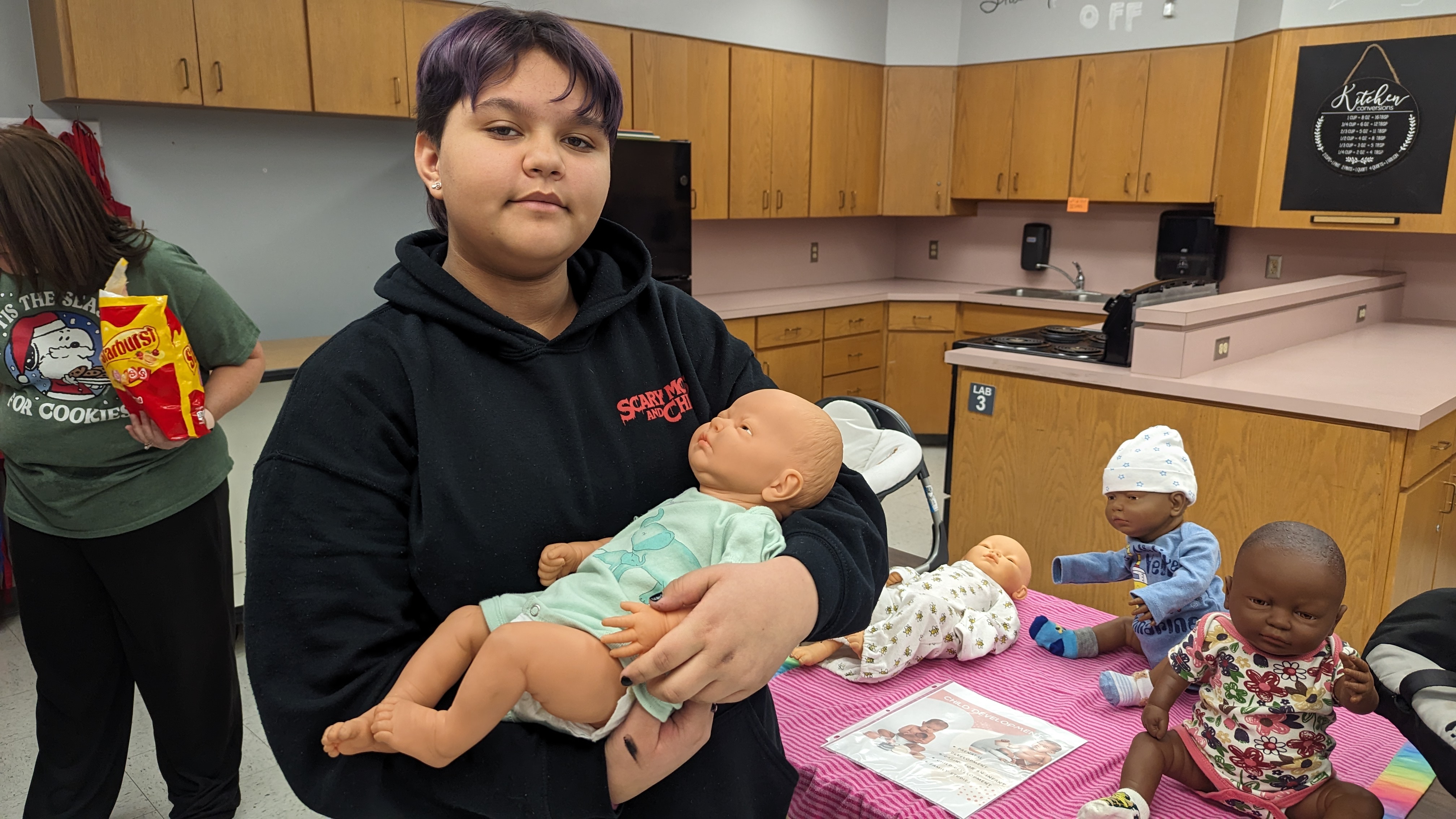 student holding baby doll