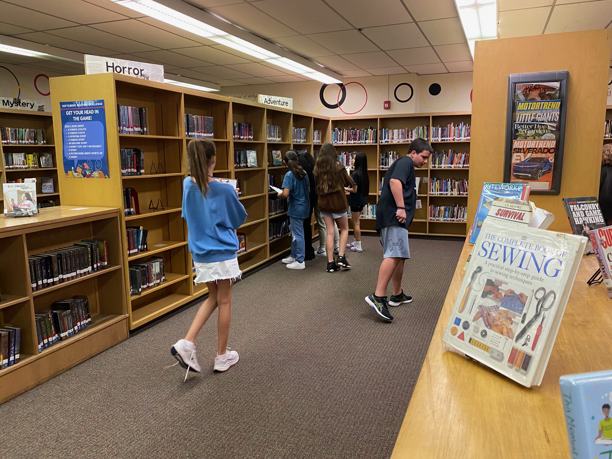 Students looking for books on library shelves