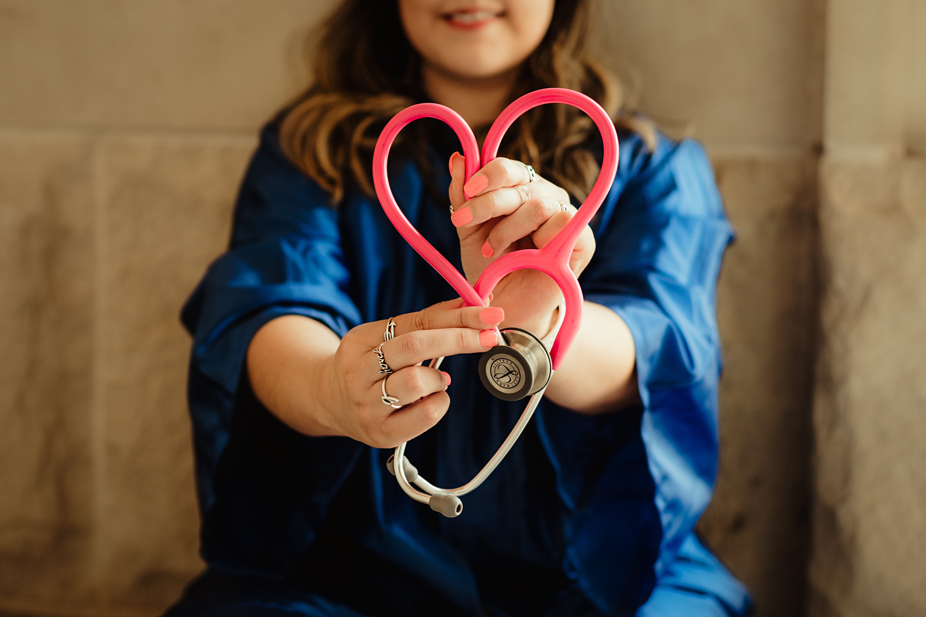 Nurse with stethoscope folded into heart shape