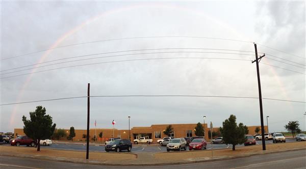 The front of Centennial Elementary School campus with a rainbow overhead