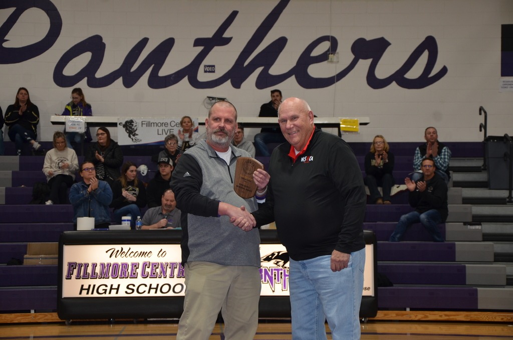 Coach Komenda receiving the NSWCA Class C Vern Ekfeldt Coach of the Year Award for 2022 at Fillmore Central High School. The award was presented by Norm Manstedt, CEO of the Nebraska Scholastic Wrestling Coaches Association.