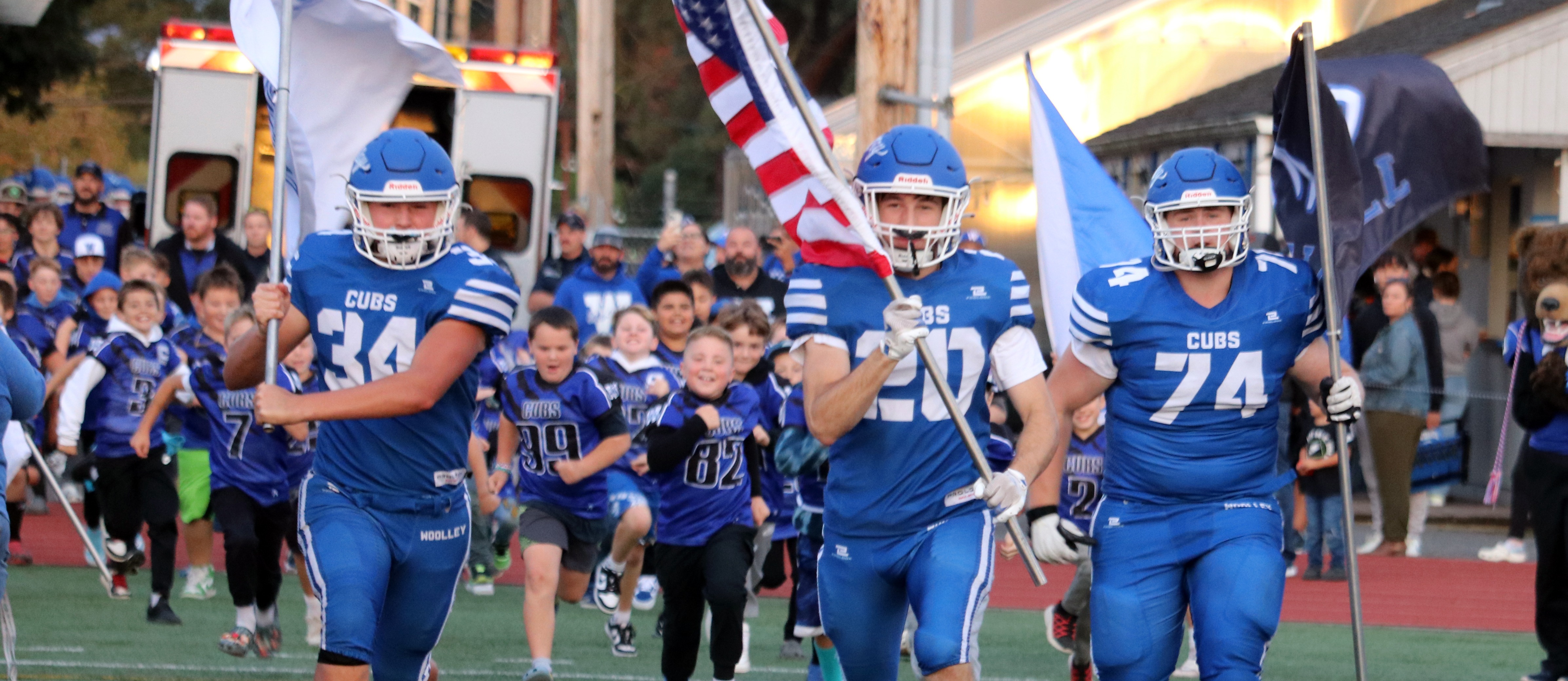 Football players run onto the field before the game on September 19, 2024. 