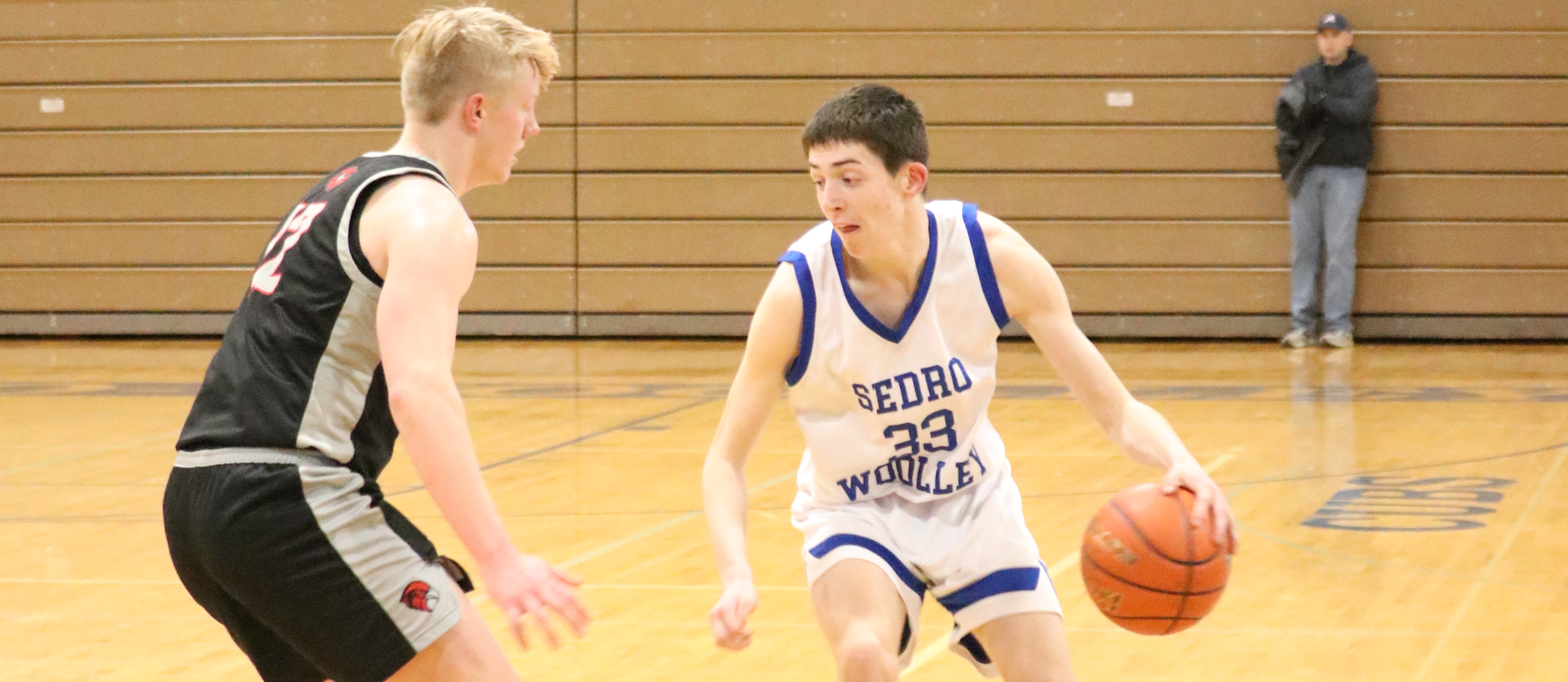 A Sedro-Woolley High School basketball player dribbles around a Bellingham High School opponent. 