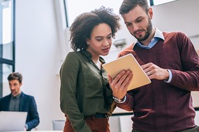 two coworkers looking at a document