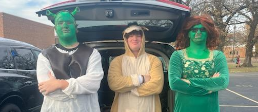 three high school students dressed in costume as Shrek, Donkey, and Fiona