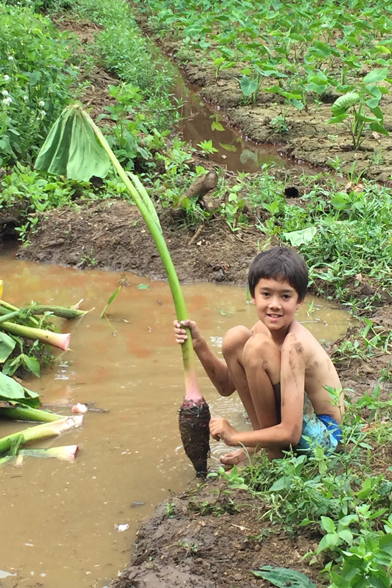 student crouched next to water holding plant