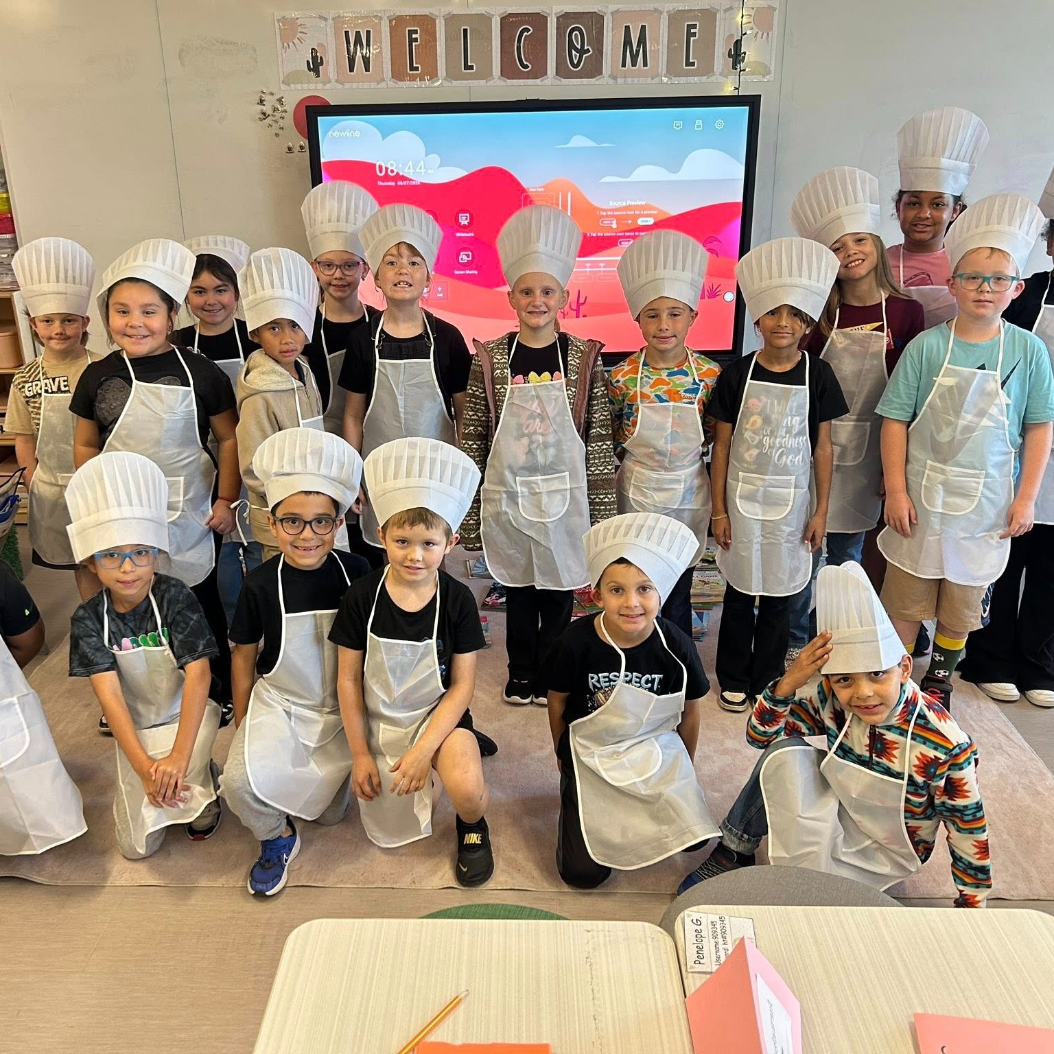 group of elementary students wearing chef hats and aprons