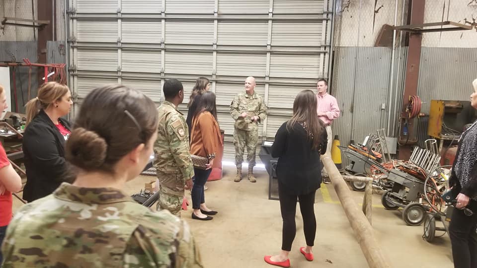 Students listen to air force instructor while touring hangar