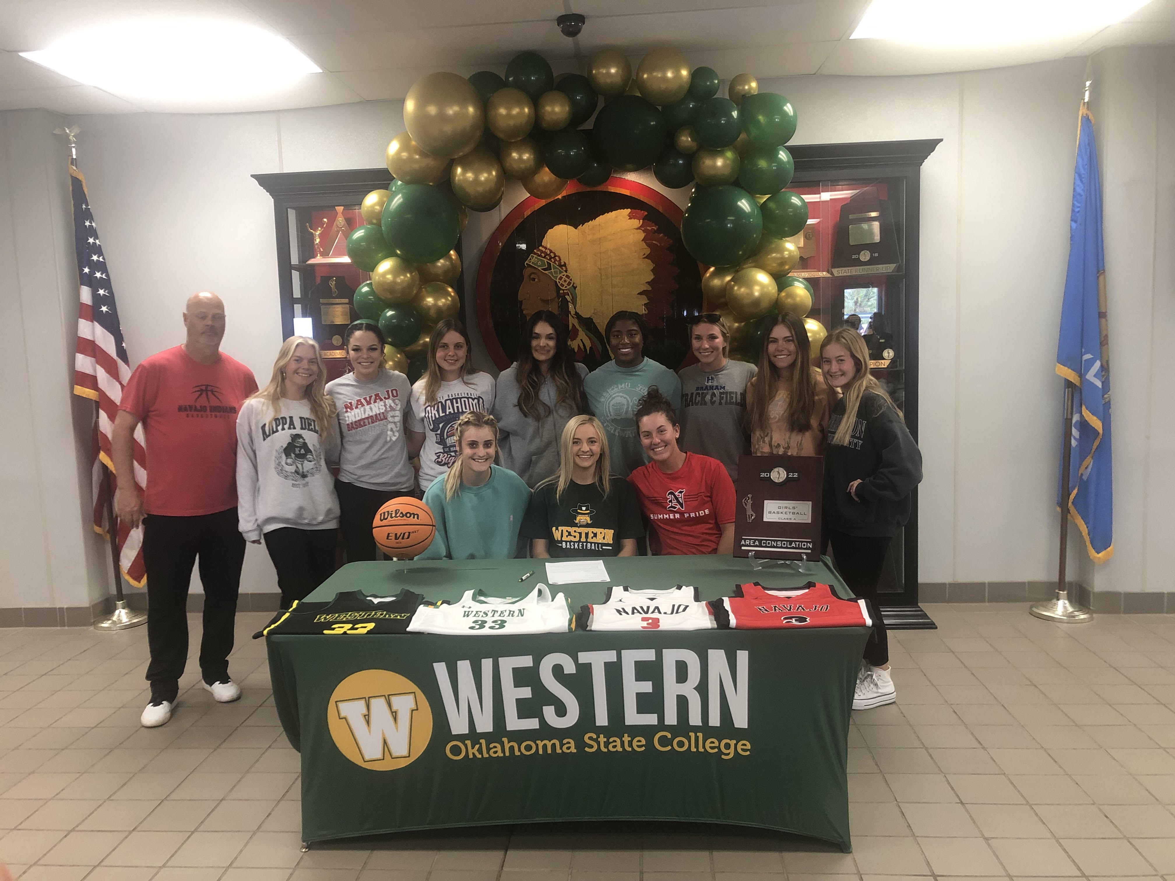 Girls sit around table decorated in college apparel