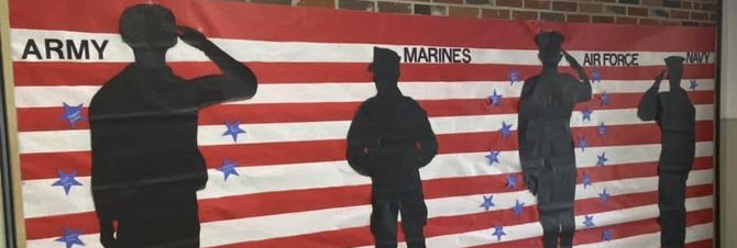 student created mural of us flag with silhouettes of service members