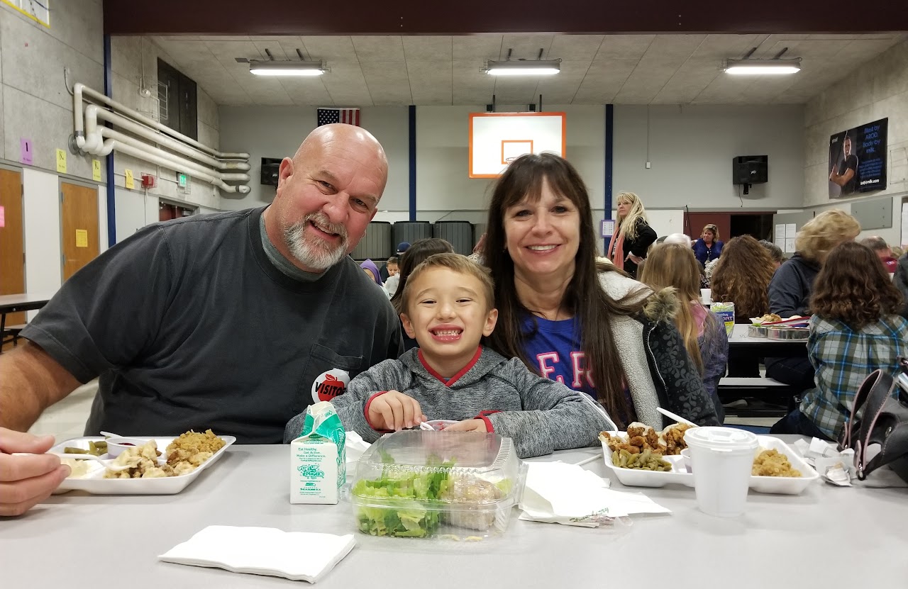 grandparents smiling with grandson at lunch