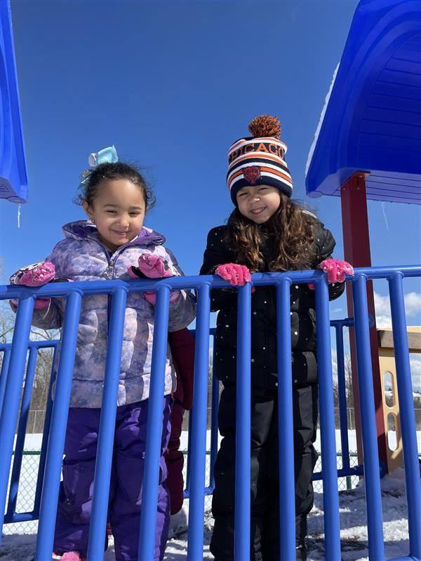 two primary students playing outside winter