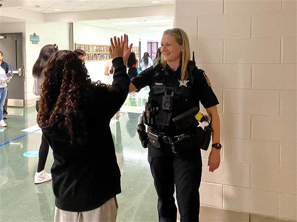 The SRO giving a student a high five.