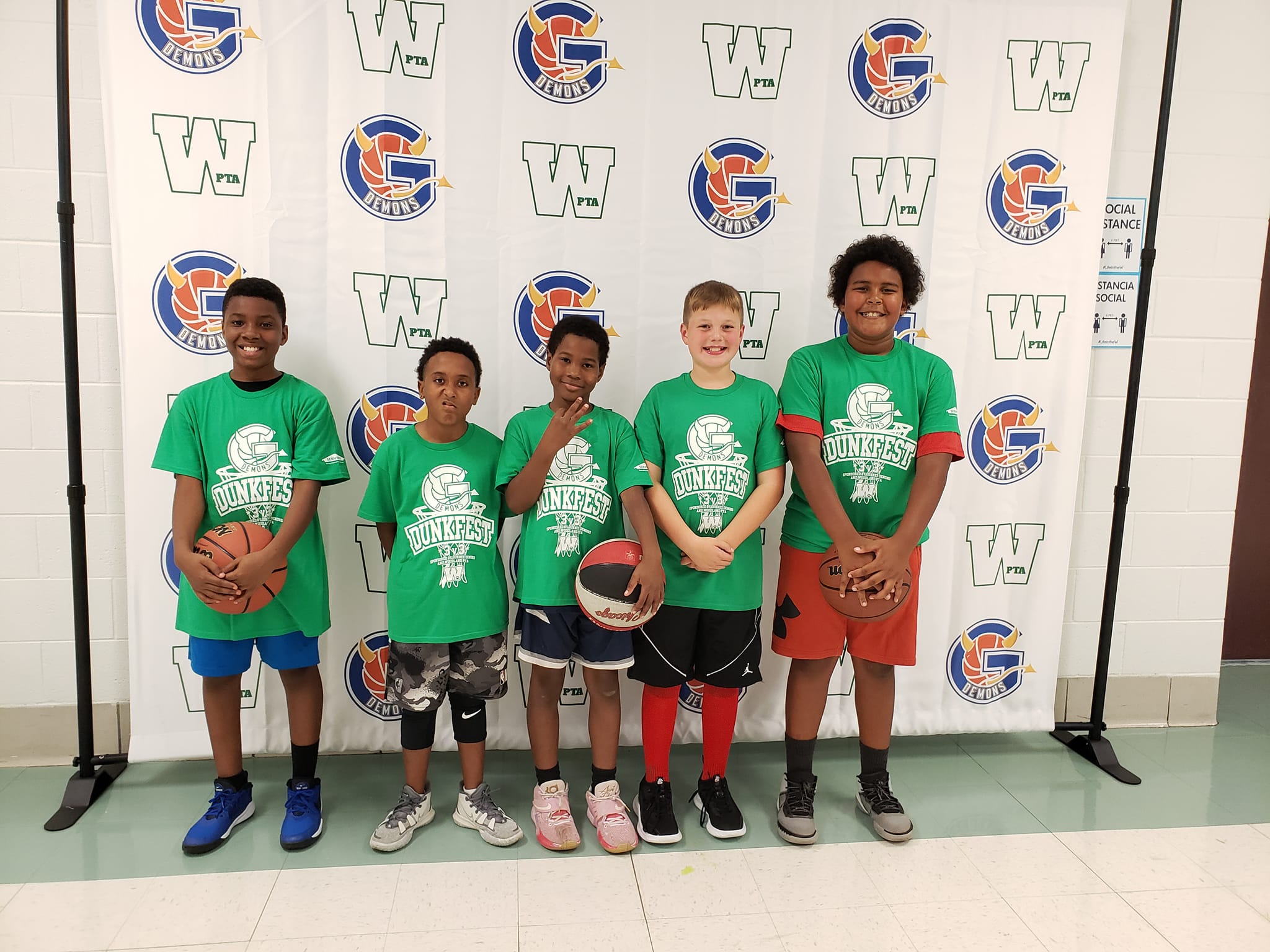 PTA Event: Dunkfest! Five school aged boys pose for a photo with a basketball after participating in a basketball contest