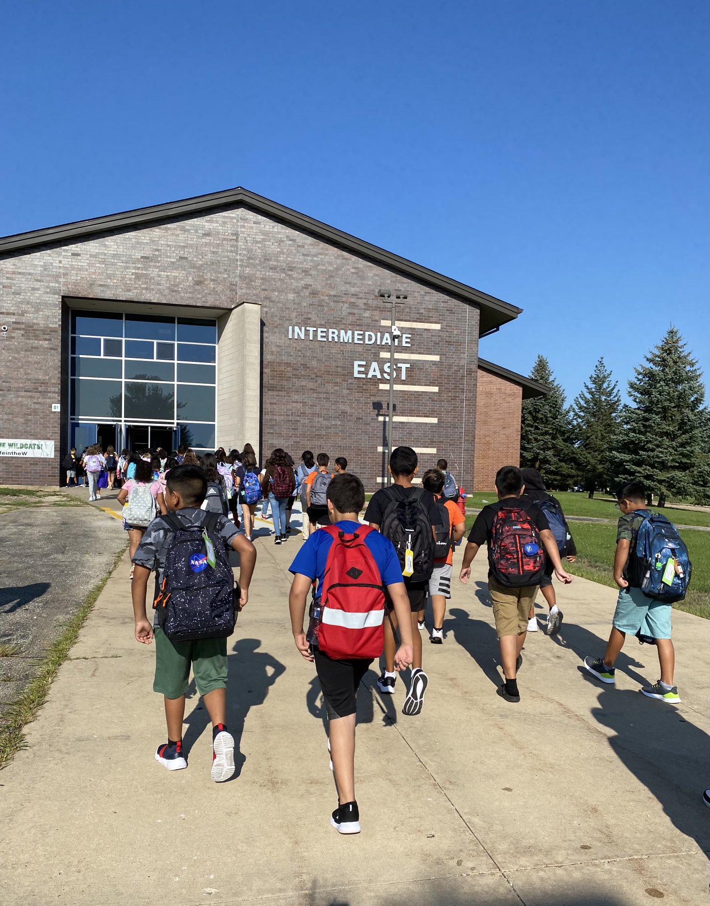 Students enter the school to start the school day