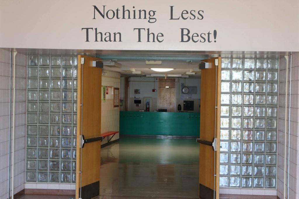 A photo of the school hallway with a saying above the door that says "Nothing Less Than the Best!"