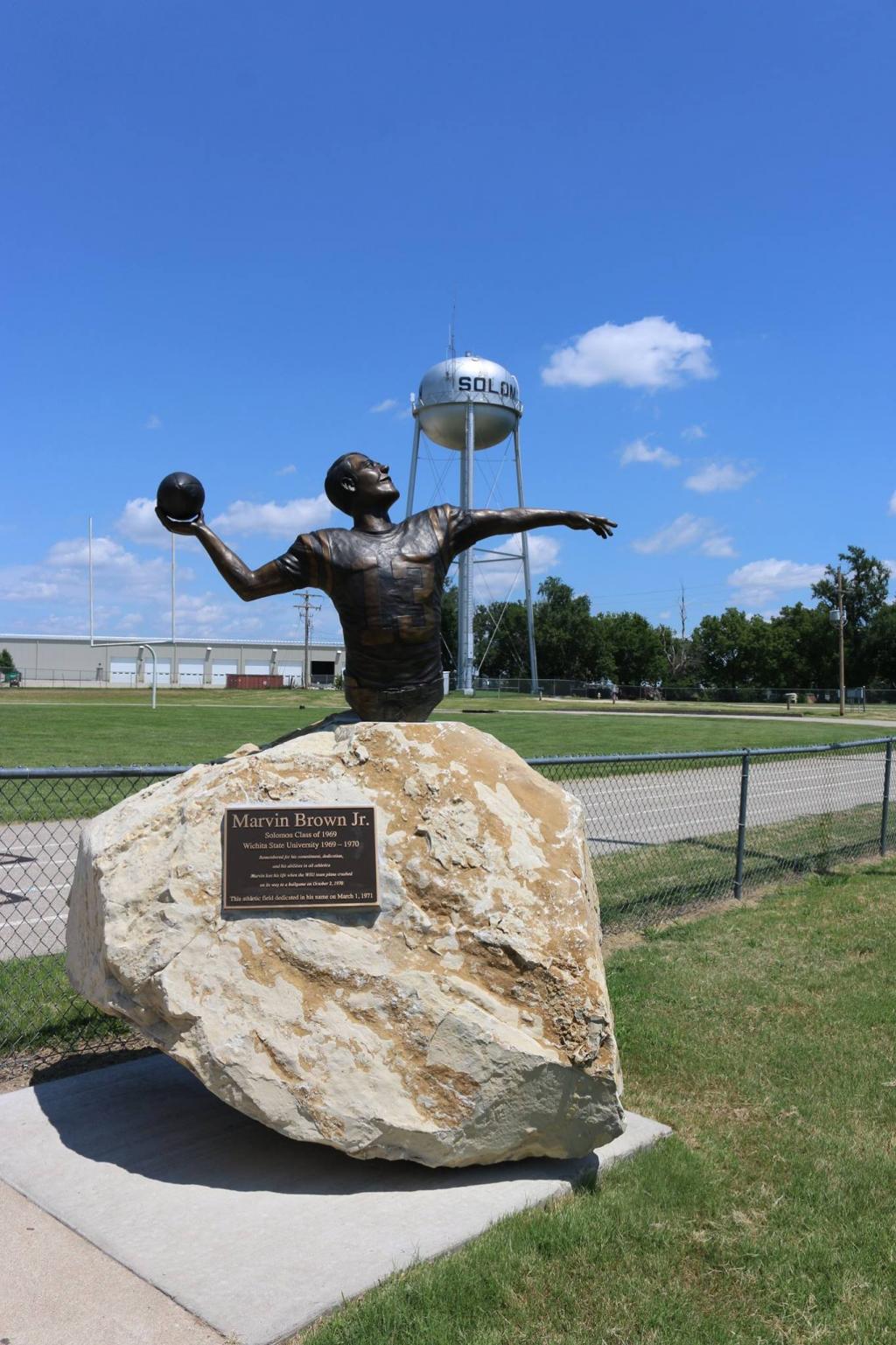 A photo of a statue of a man throwing a football