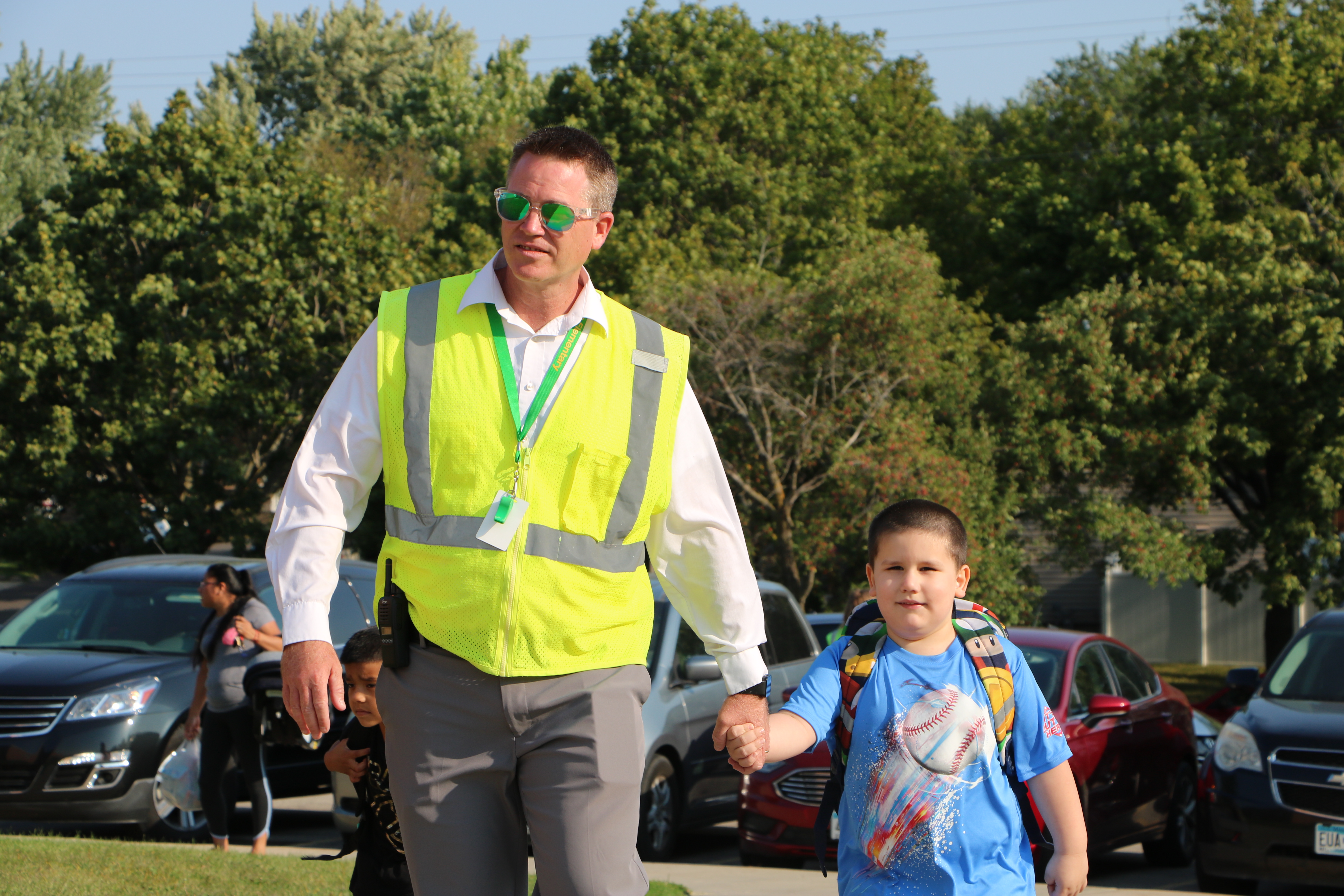 Principal Kris Davidson walking kindergartener