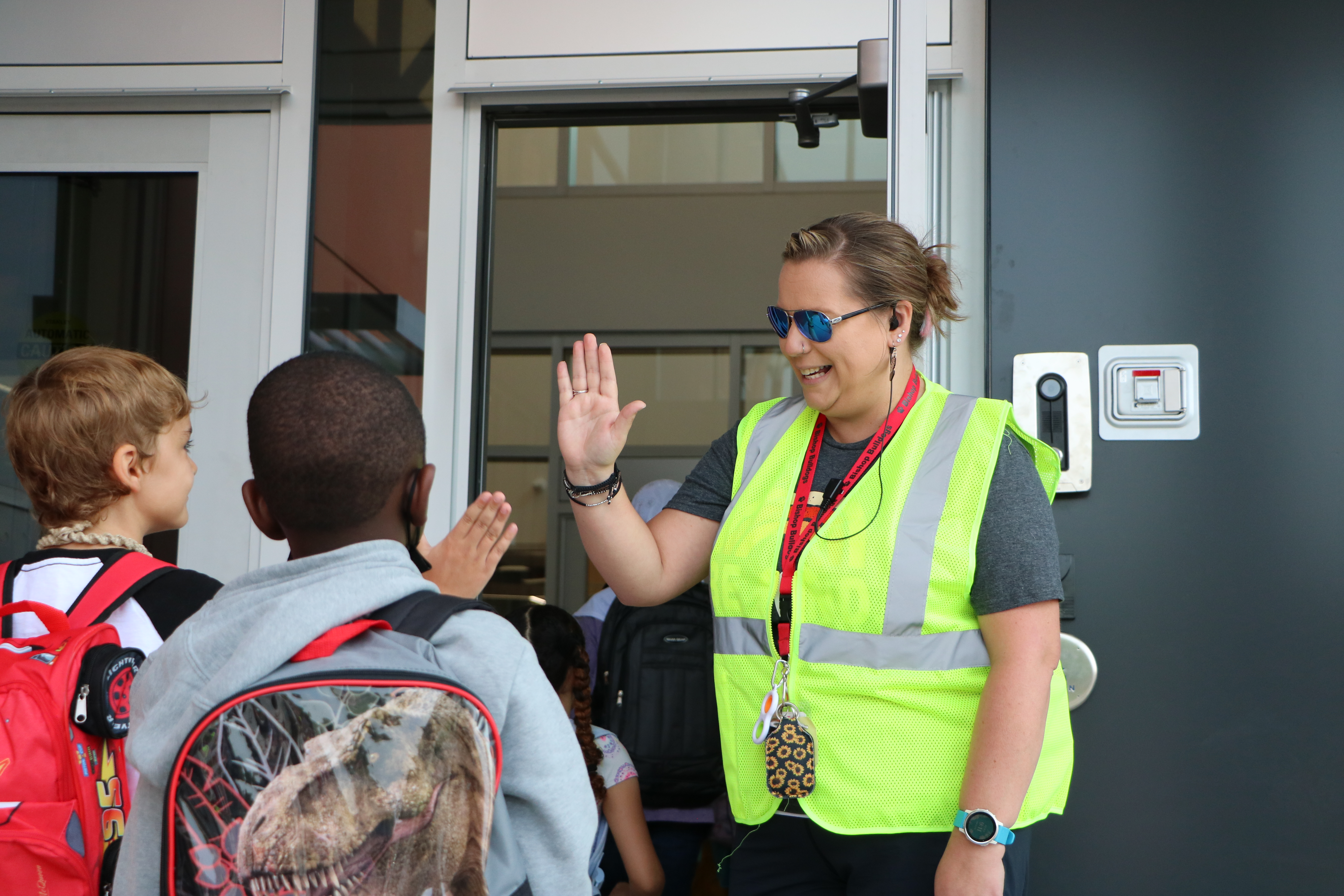 Staff high fiving students entering the school