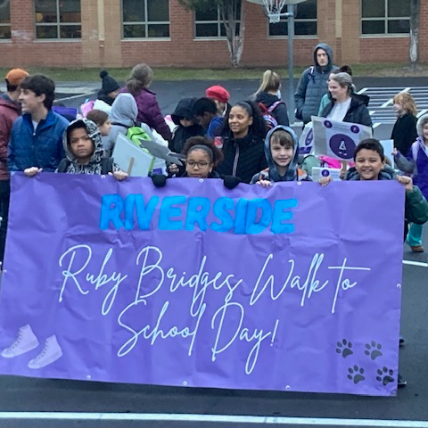 Students holding banner for ruby bridges walk to school day at Riverside