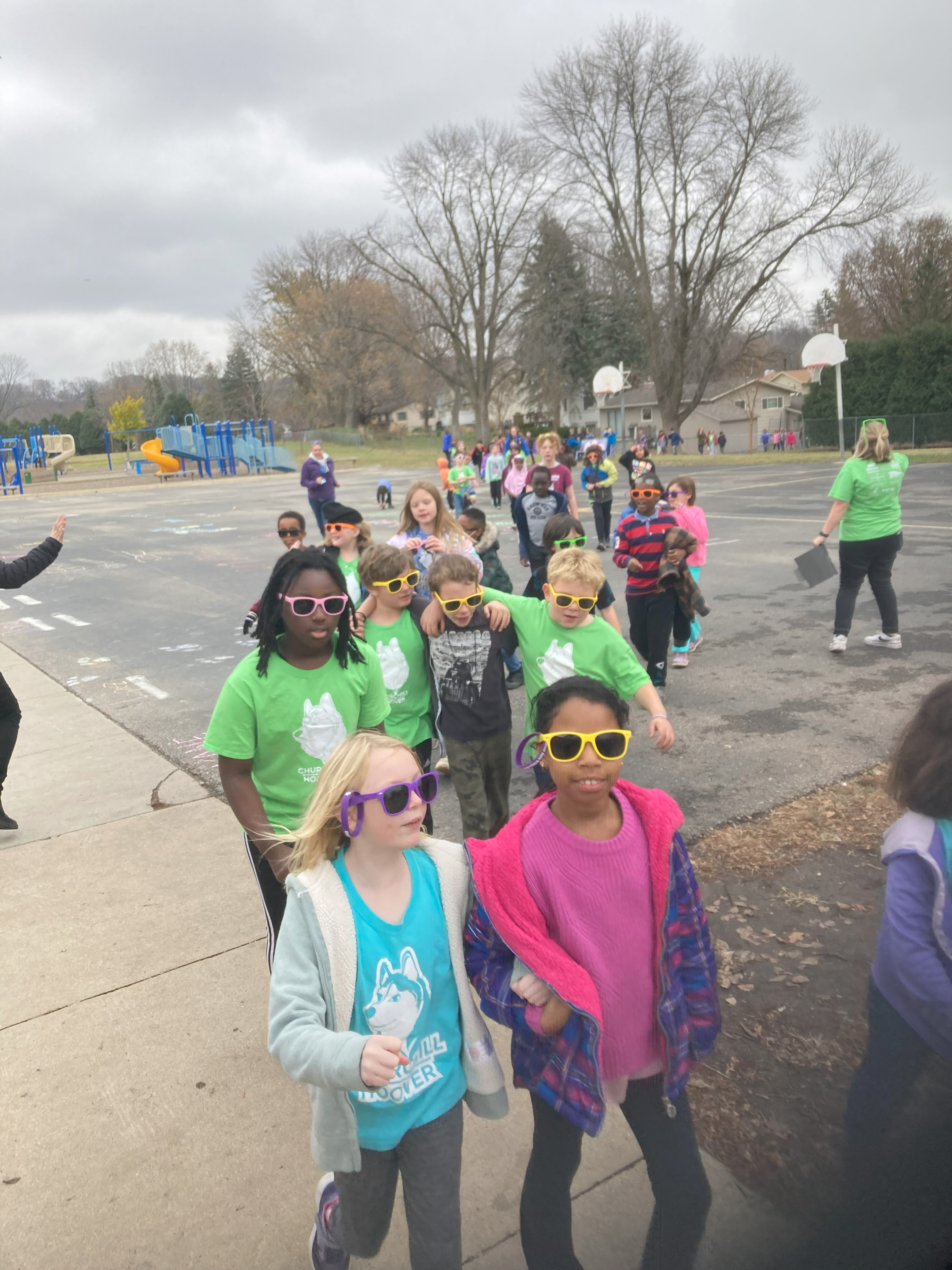 students walking together through playground smiling and hugging