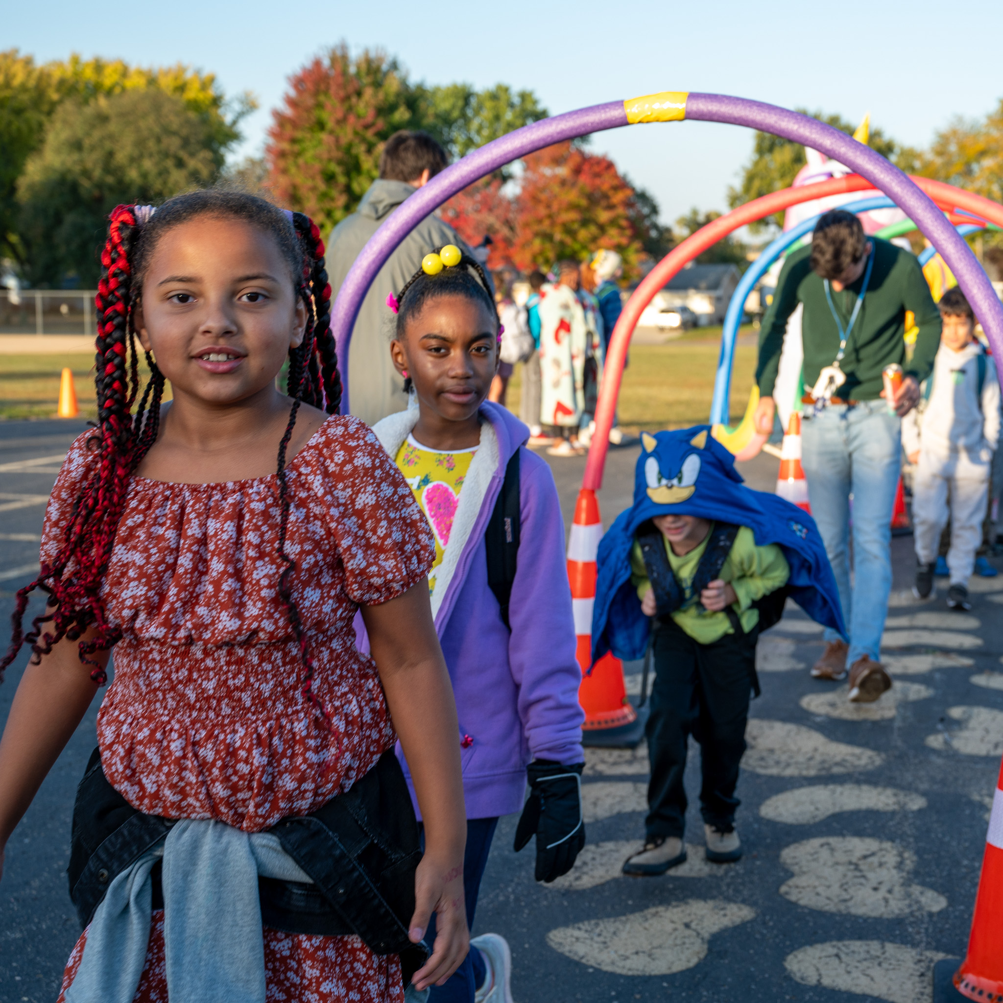 Students smiling walking through arch to school