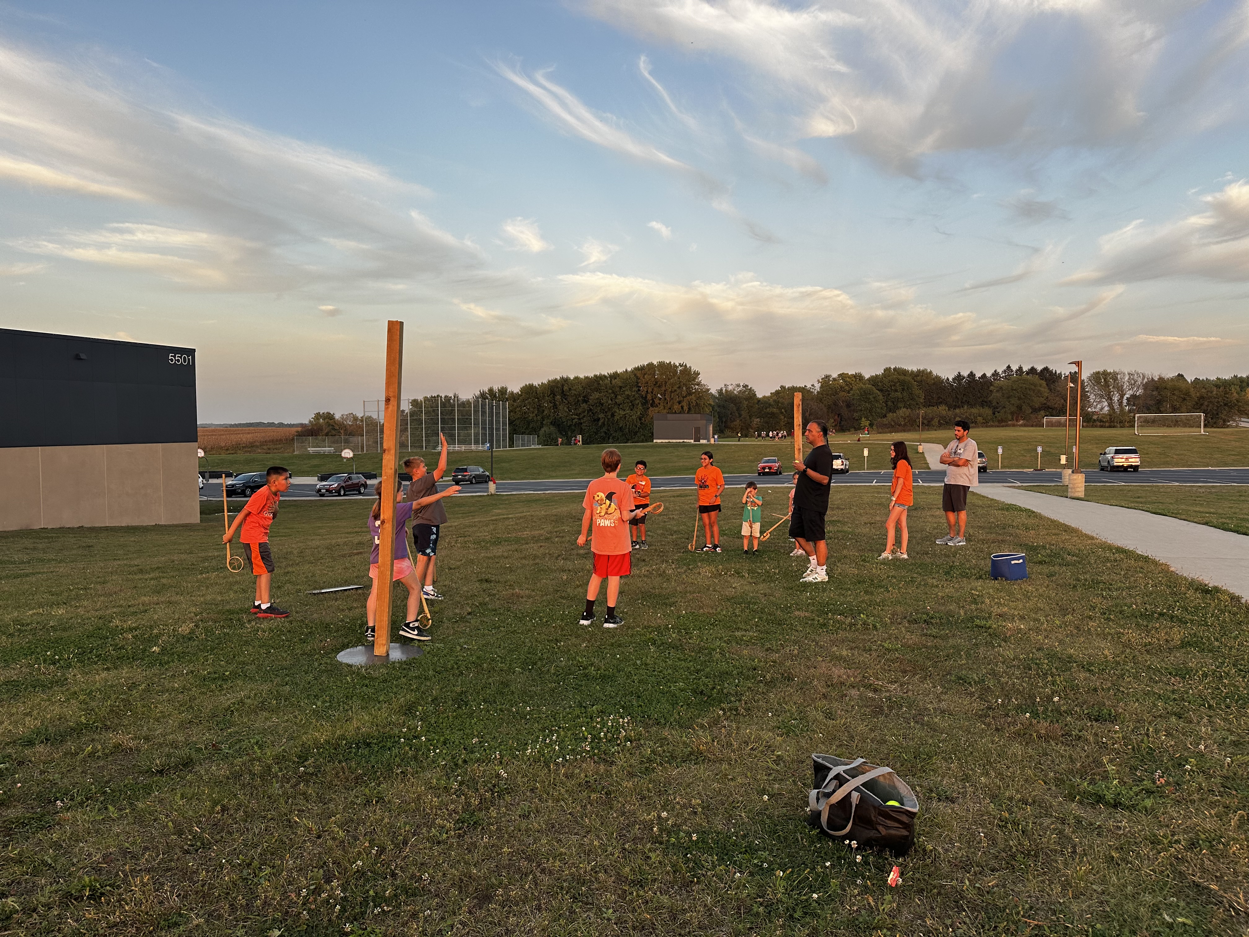 AIE students learning to play lacrosse outside on the grass