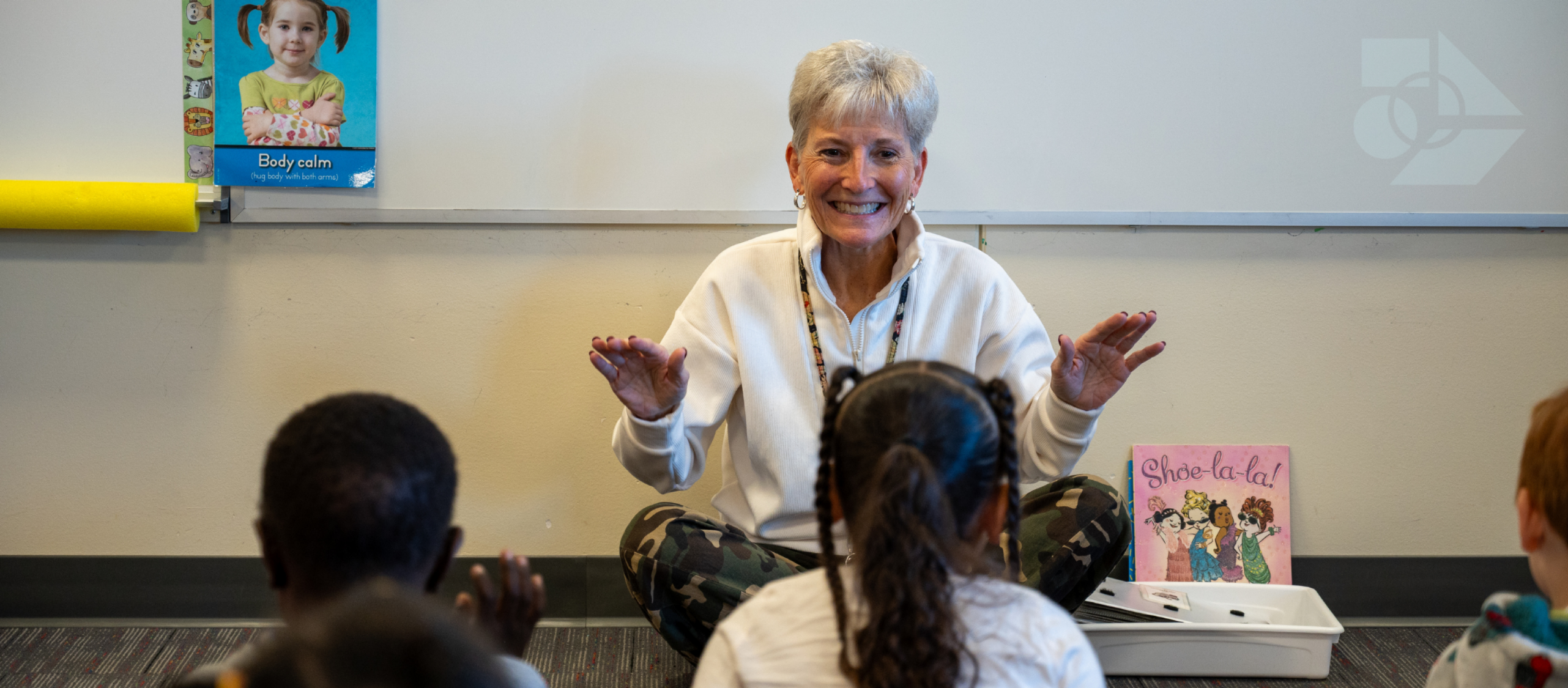 Teacher in front of class clapping a pattern on their legs.