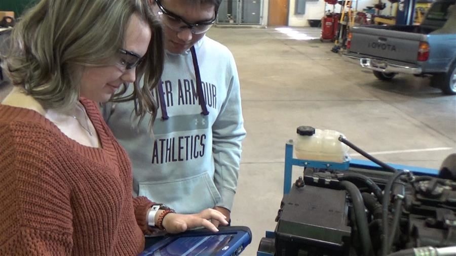 two students look at an ipad