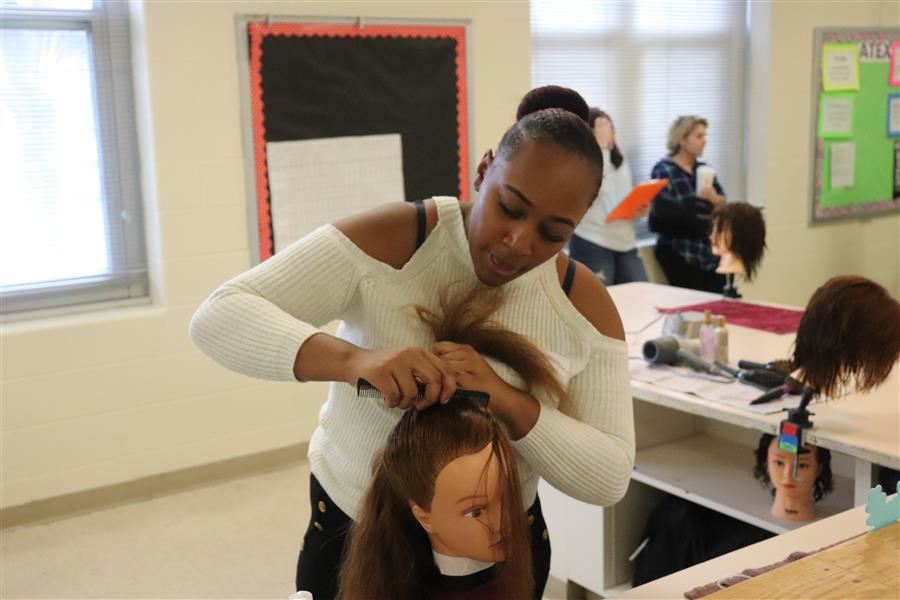 girl does doll's hair