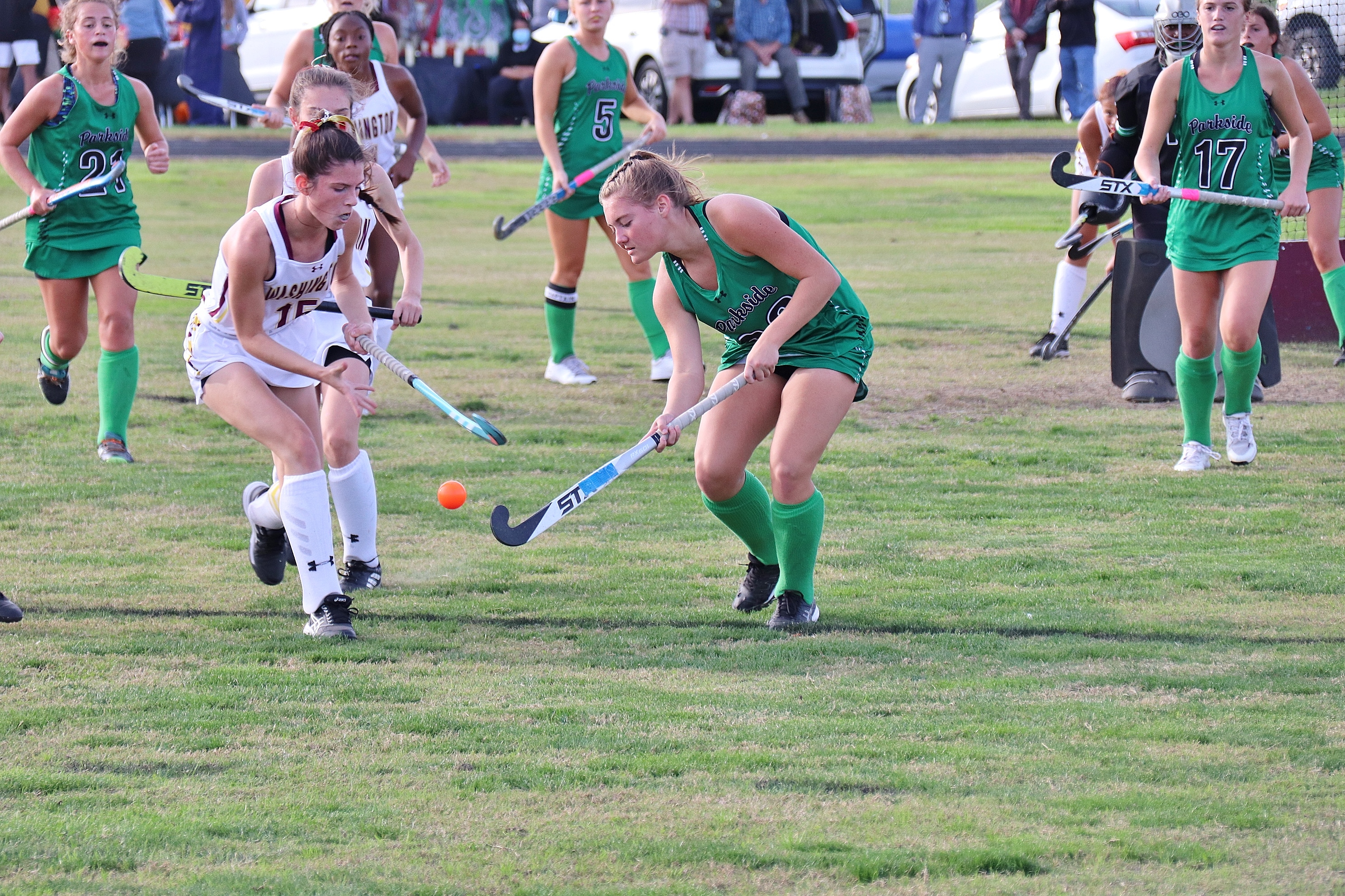 player swinging field hockey stick at the ball