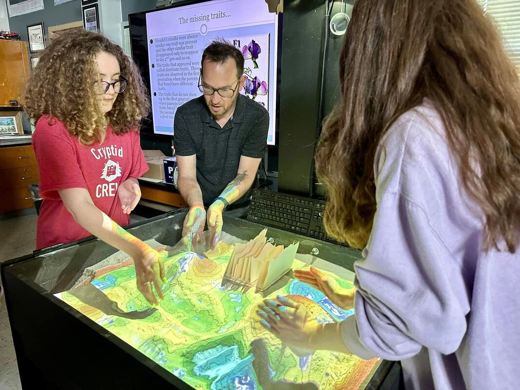 Image of NeXgen Students and teacher working on a project