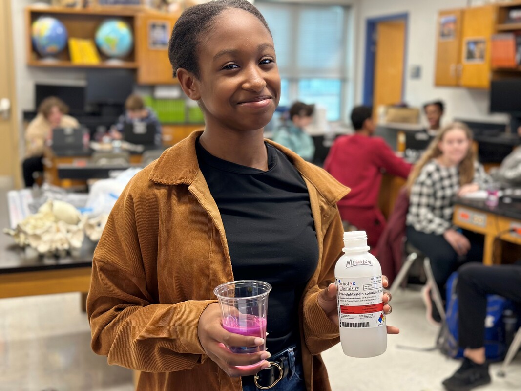 Image of female student holding chemicals for an experiment