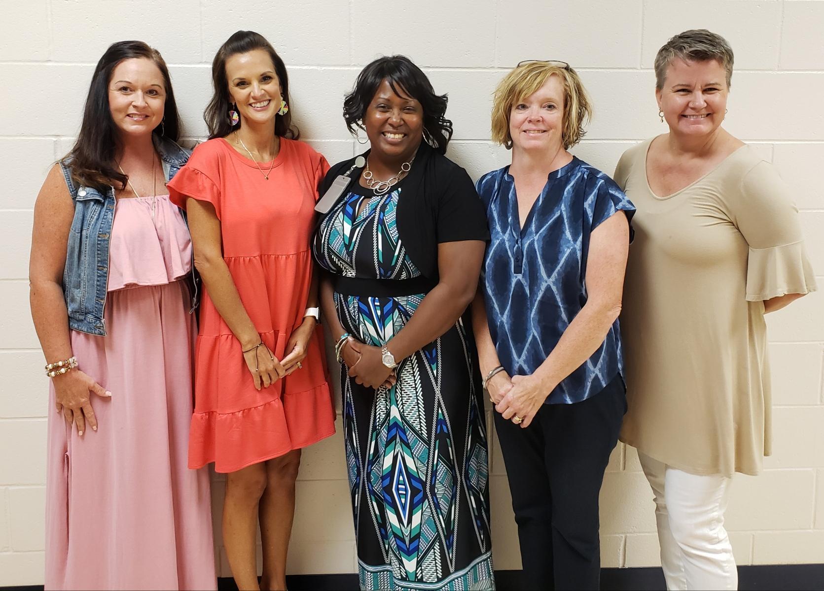 Ms. Brie, Ms. Register, Ms. Lucas, Ms. Gattis, Ms. John standing in the hallway for a group photo