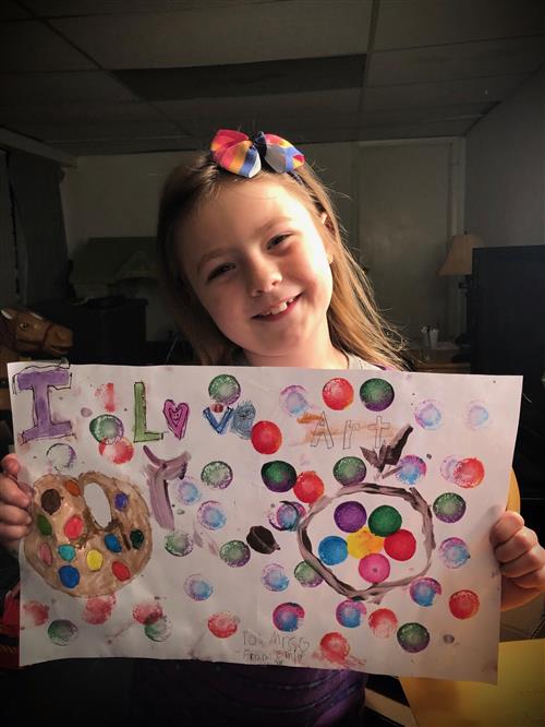 Student holding up a painting 