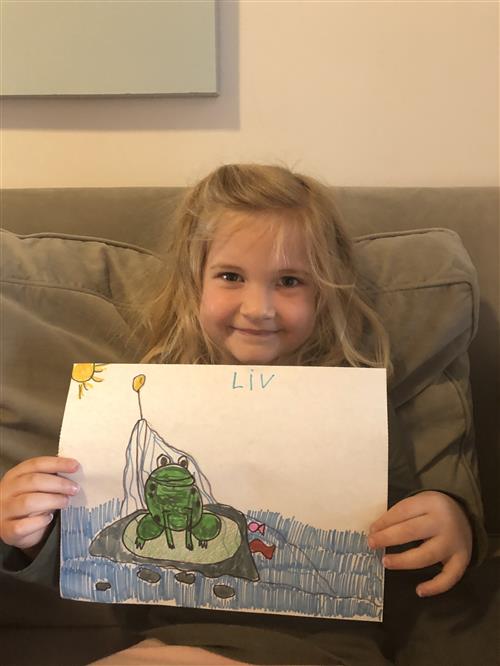 Student holding up a picture of a frog