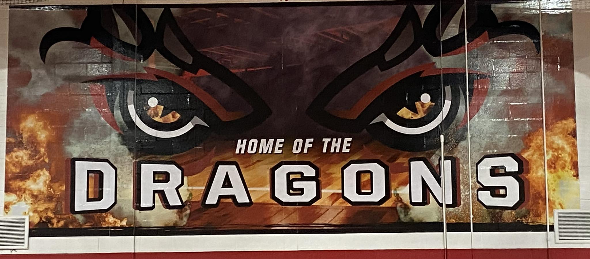 Dragon banner with Dragon Eyes and Home of the Dragon that is displayed in the gym