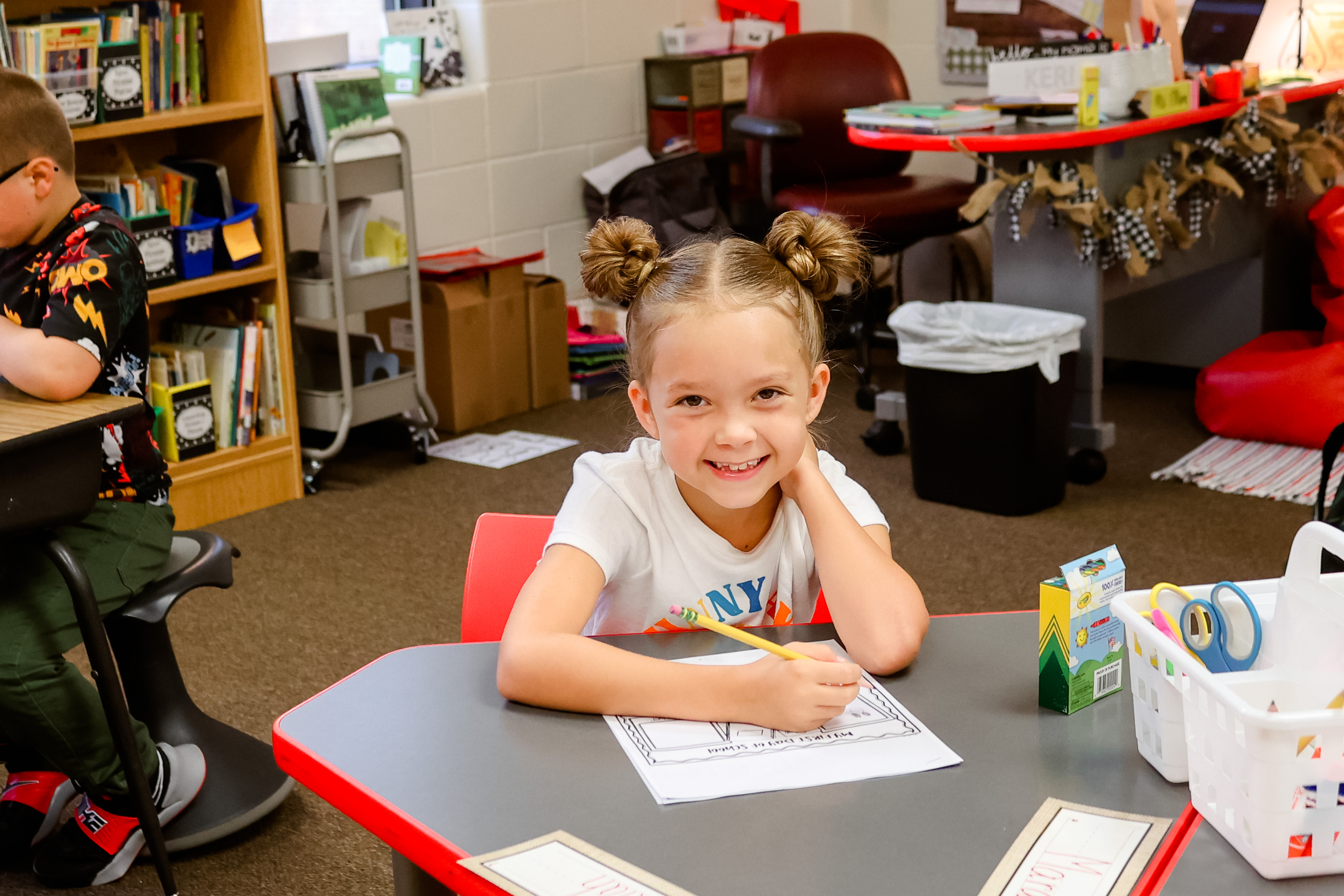 a student smiles at her desk