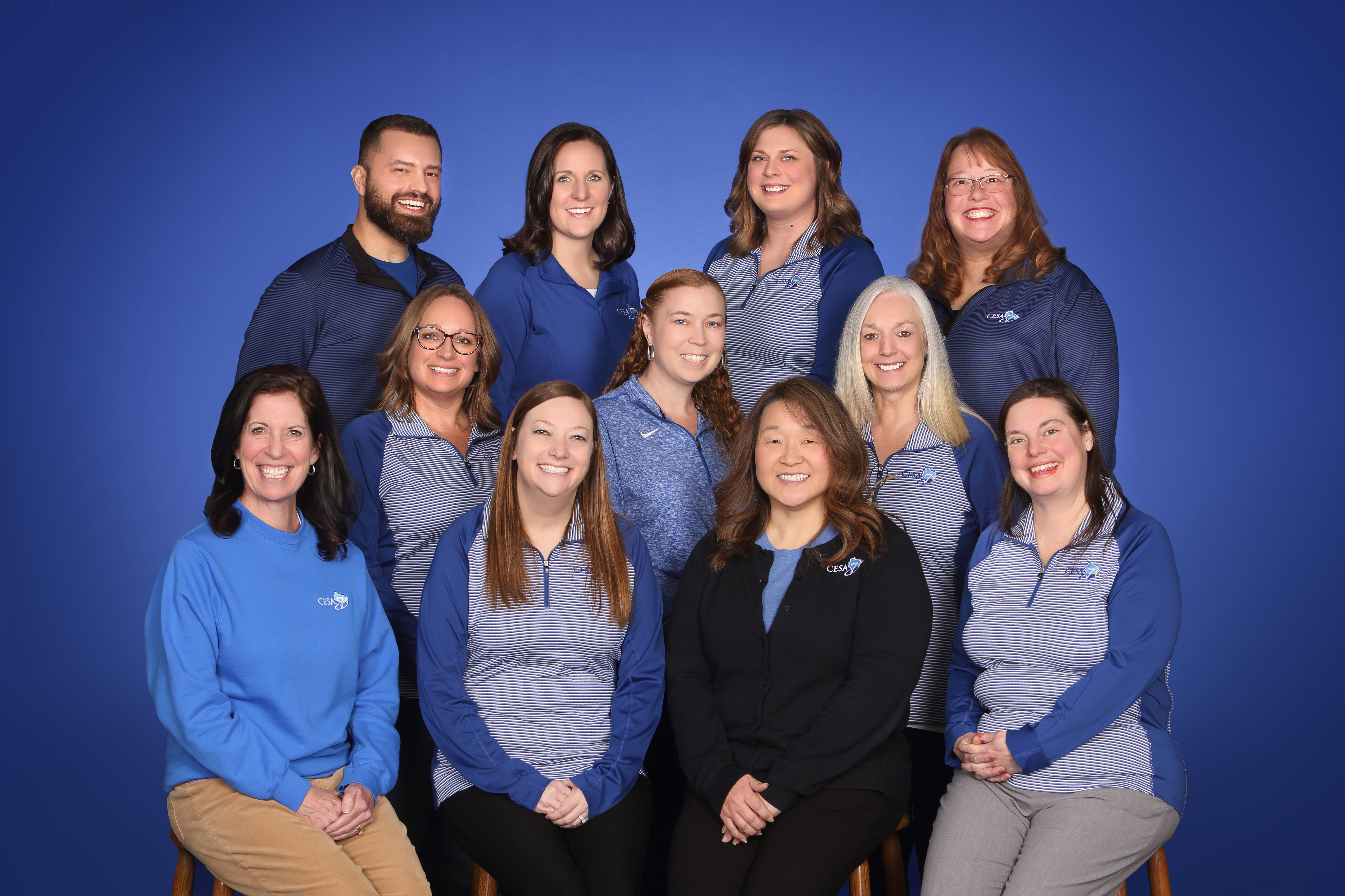 Blue background group photo of CESA 7 Learning Services team members