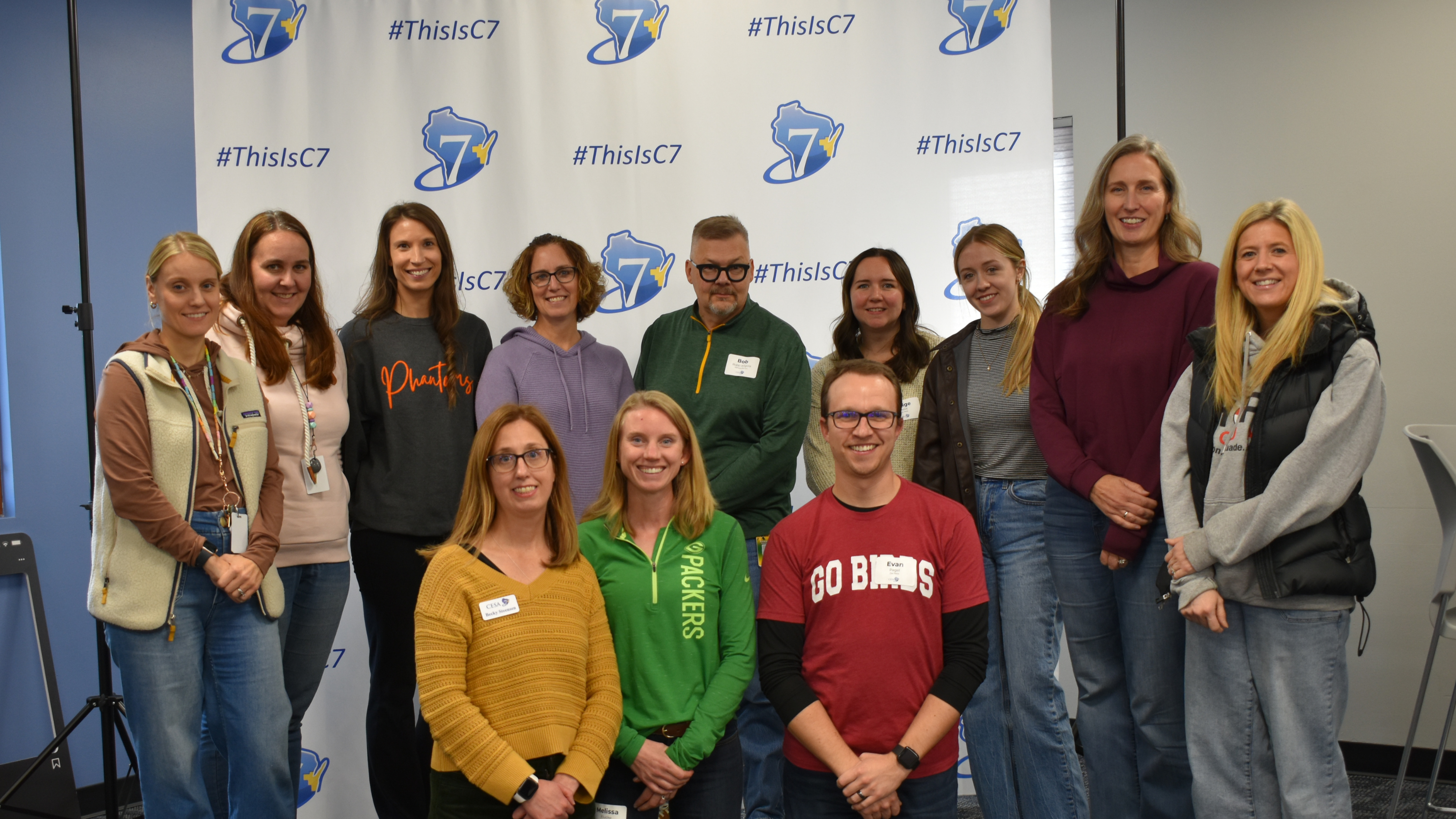 Group of C7 School Psychologists standing and kneeling in front of C7 backdrop